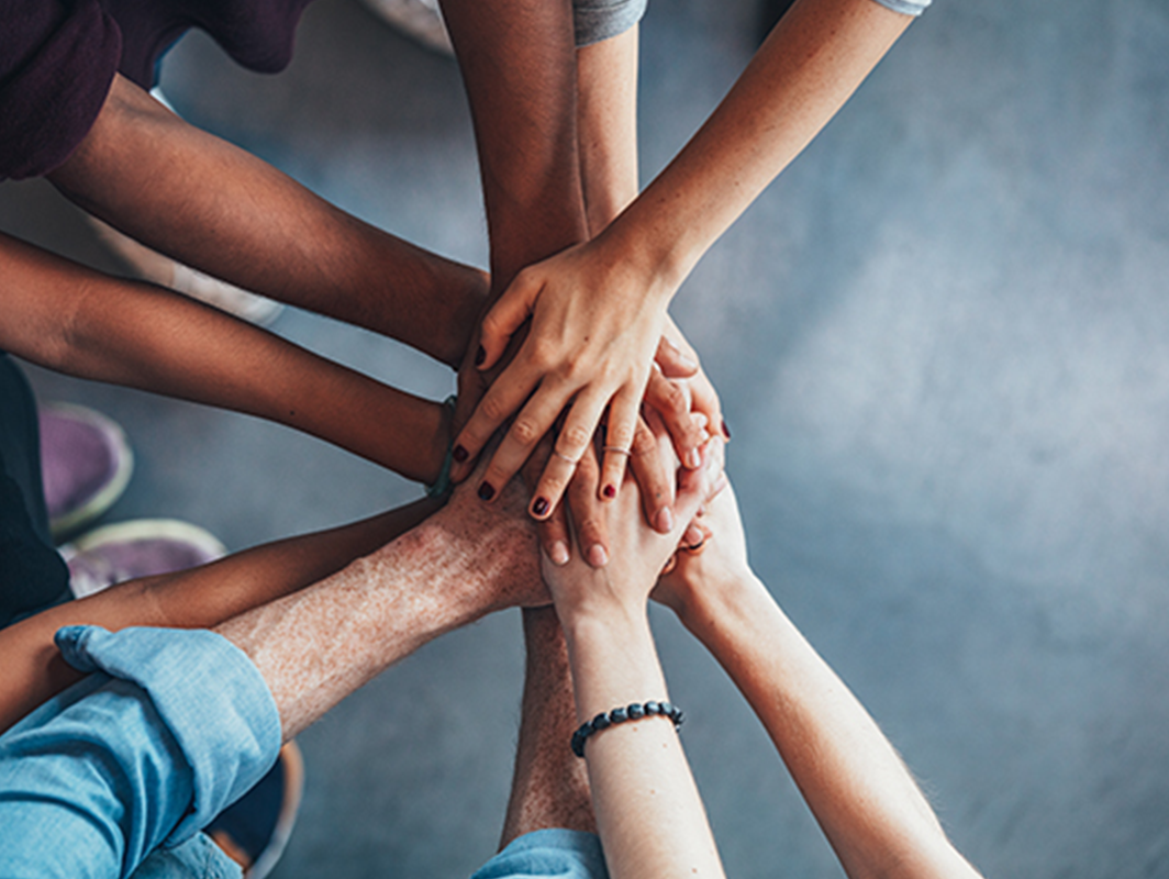 Diverse hands reaching in and overlapping each other