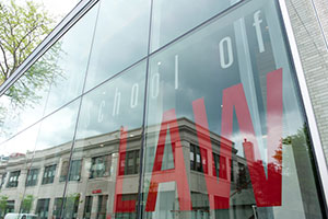 Angled view of School of Law exterior. 'School of Law' is printed on the glass of a large window.