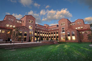 Brick law building at dusk. Yellow light shines in the windows.