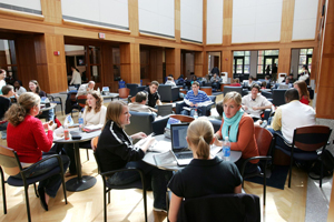 Students congregate at cafe tables with food or laptops.