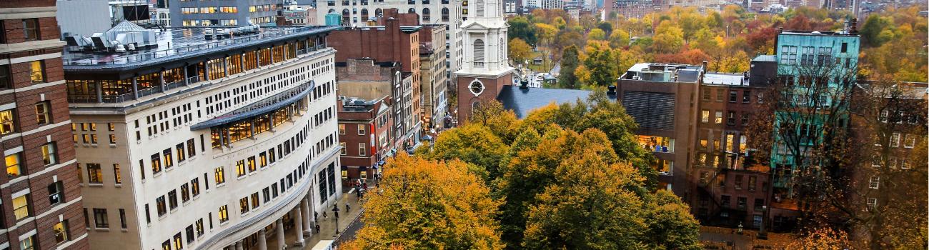 Suffolk Law amidst the downtown Boston city skyline surrounded by fall foliage 