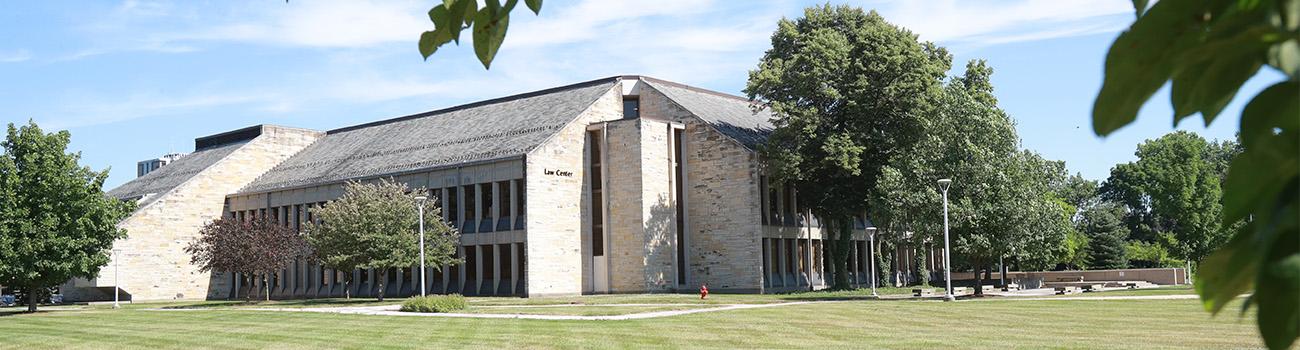 scenic image of law center building with grass field and trees