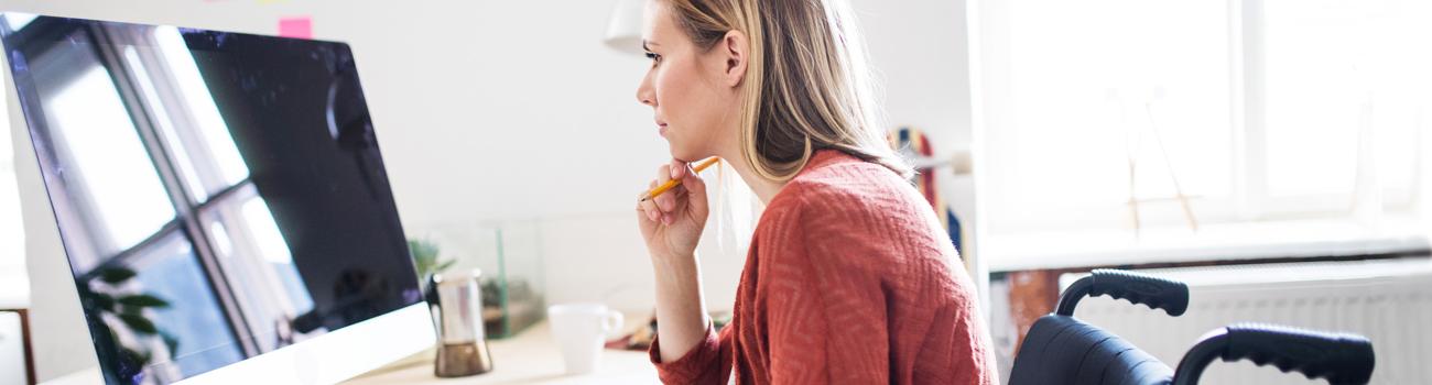 Person in a wheelchair looking at a computer monitor