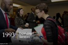 A law school representative shows an academic brochure to a prospective law student at an LSAC Law School Forum. Image copyright LSAC.