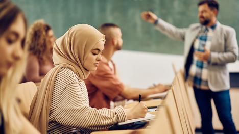 Diverse students in classroom with professor