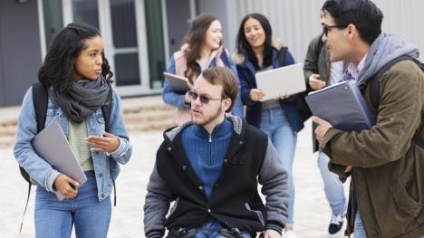 law student using a wheelchair and talking with peers