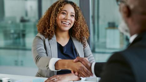 Two people shake hands at a job interview