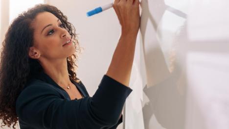 A woman writes on a whiteboard