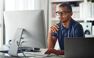 Law student at desk looking at laptop