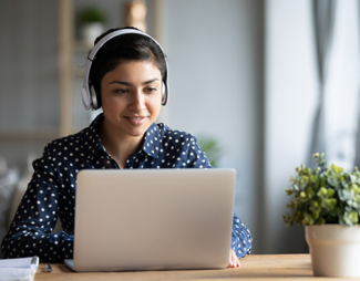 wearing headphones, studying on a laptop