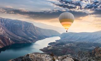 Hot air balloon floating above mountain range