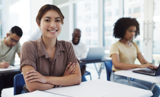 Law student in classroom with arms crossed, smiling at camera