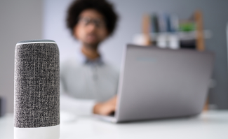 Law student at laptop in background with bluetooth speaker in foreground