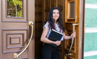 Law student standing in doorway with books in hand