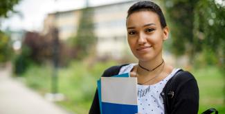 Law student smiling, holding folders