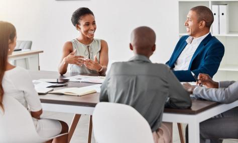 Diverse, professional group of people conducting a lively meeting. 