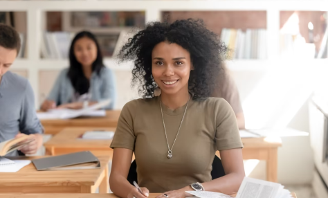 student seated at desk smiling