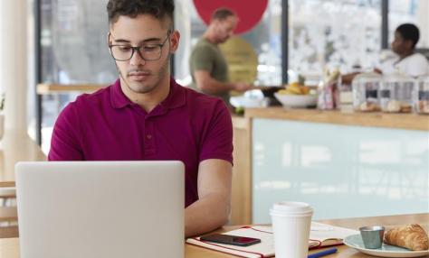 A young man sitting at a laptop.