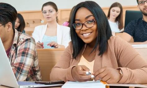 A smiling young woman student amidst a group of students. 