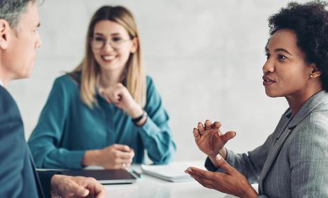 A man and two women having a business meeting. 