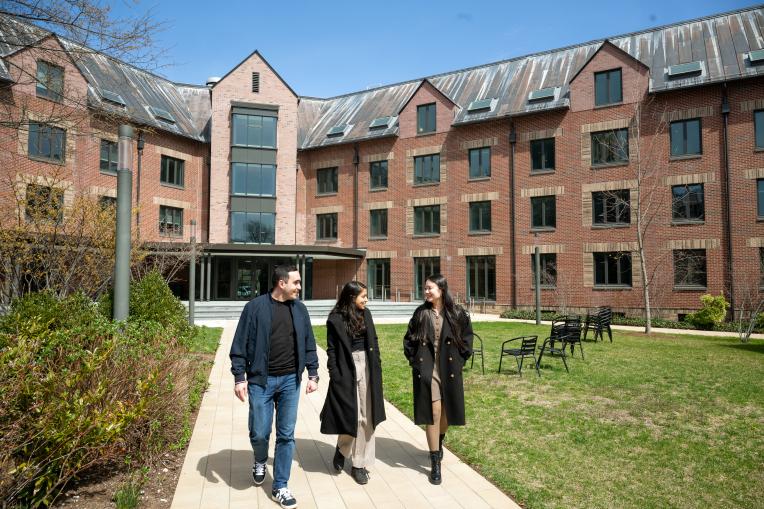 Three people walking out of dorm