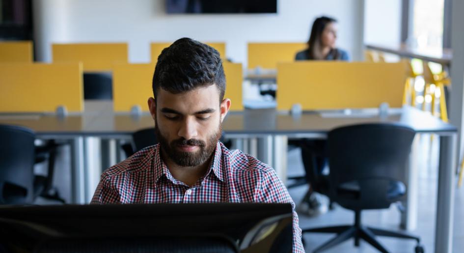 A man types on a computer in a test center environment