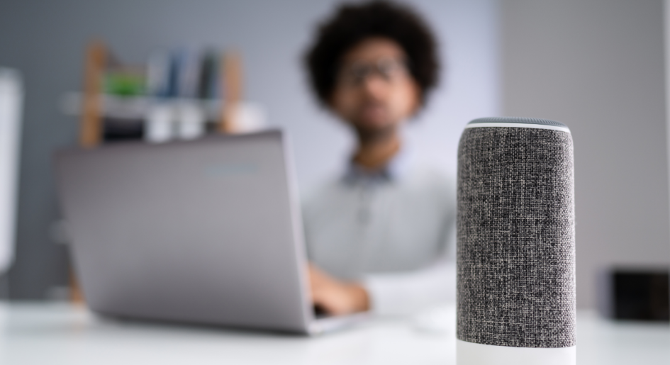 Person at desk with laptop and Amazon Echo device.