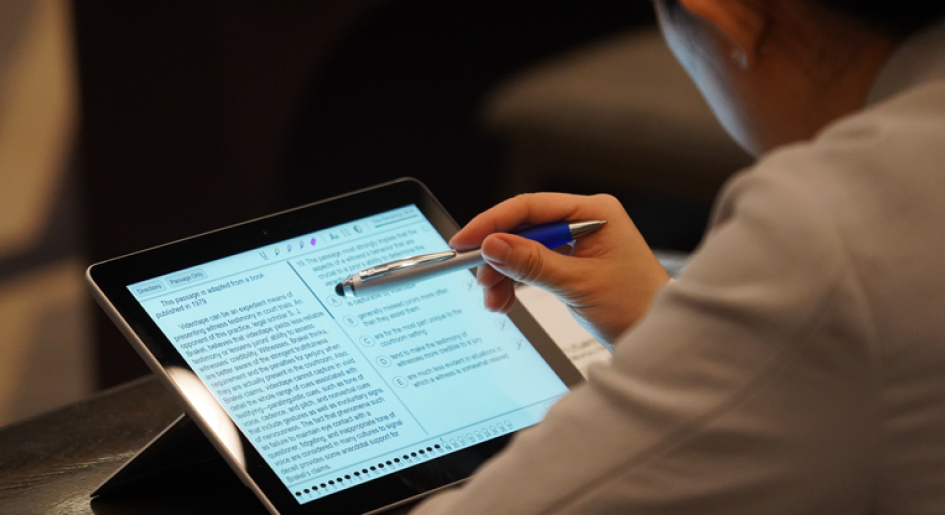 A test taker using a stylus to interact with the Digital LSAT