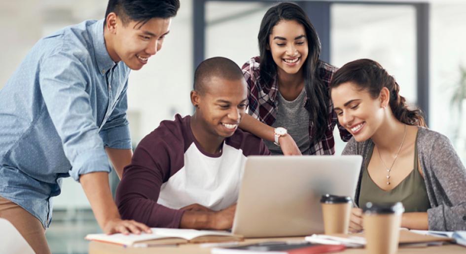 Diverse students gathered around laptop