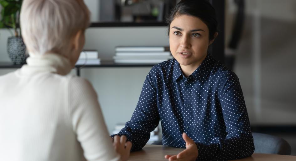 A young woman sits in a job interview with an older woman