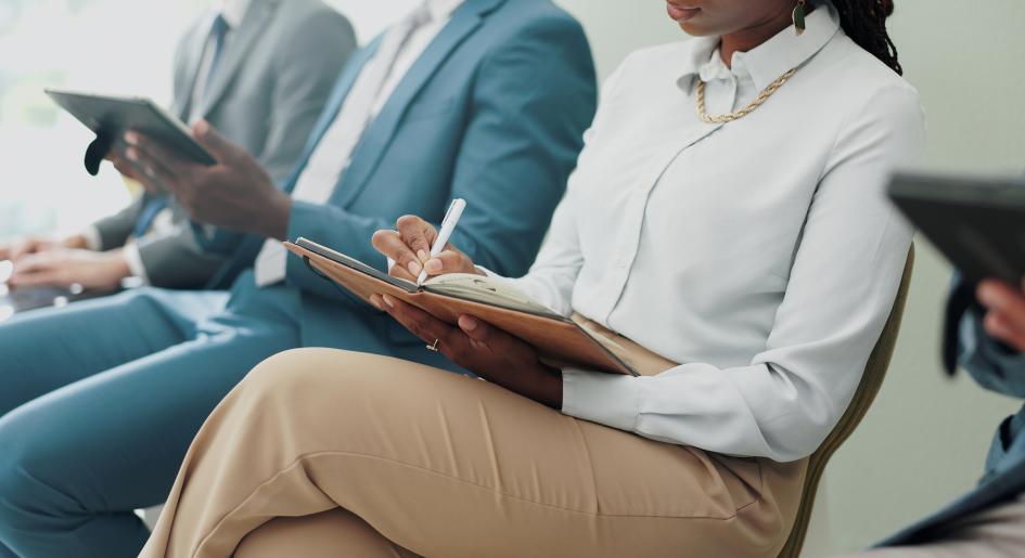 People sit in a line waiting for a job interview