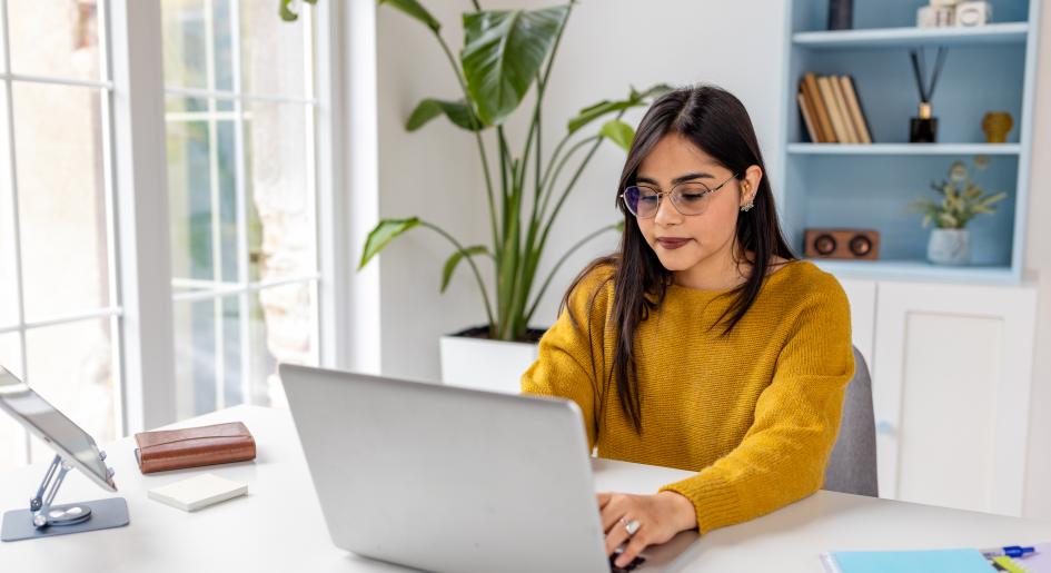A woman types on a laptop