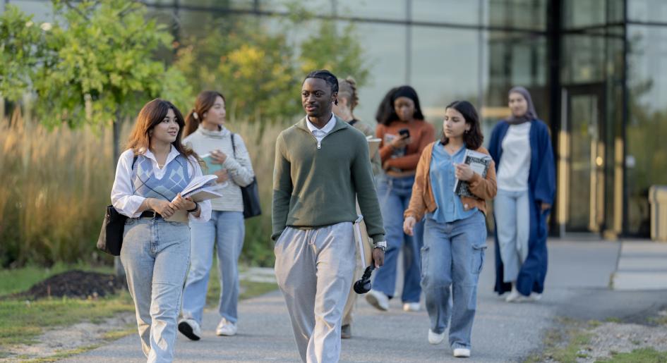 A group of students walks across a college campus