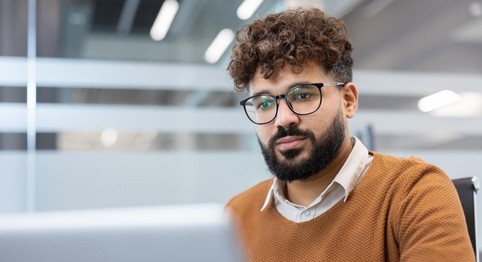 A man types on a laptop