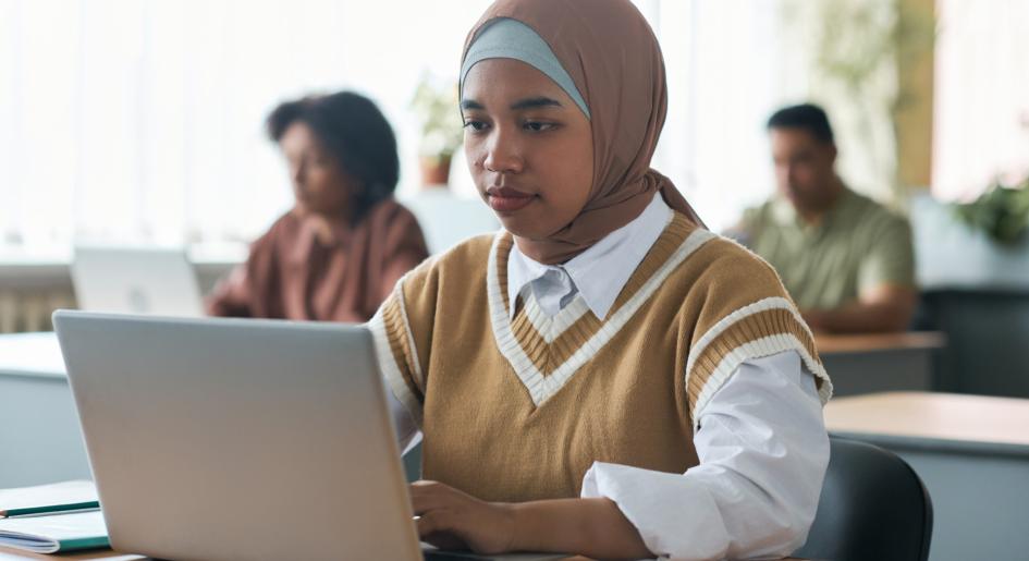 a young woman types on a laptop