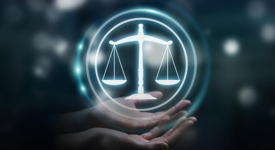 Hands presenting hologram of scales of justice
