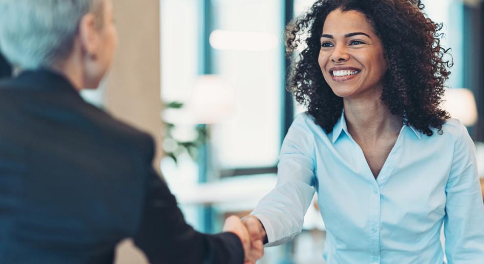 Student shaking hands with law school representative