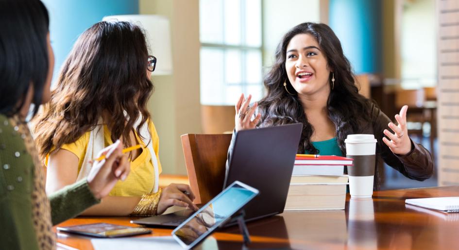 Law students conversing at table in study area