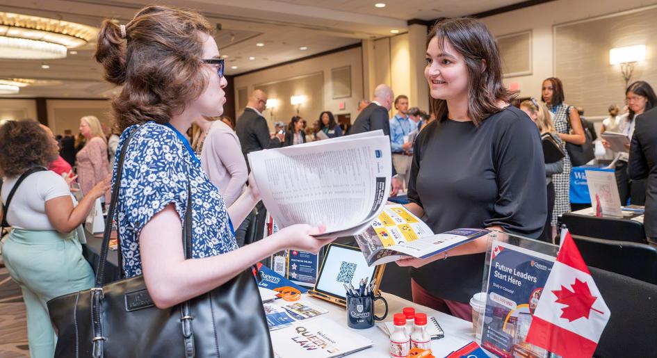 A forum attendee speaks to a law school representative at an in-person law school forum