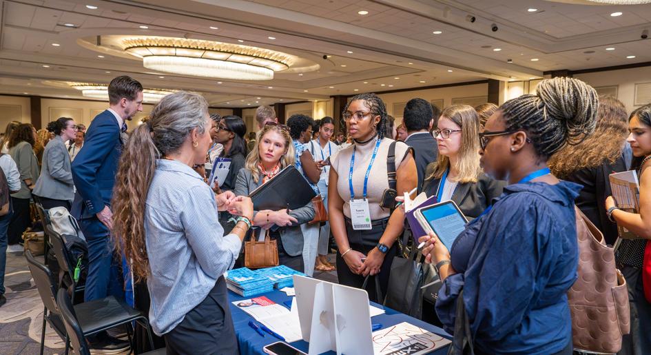 Some prospective law students speak with a law school representative at a forum