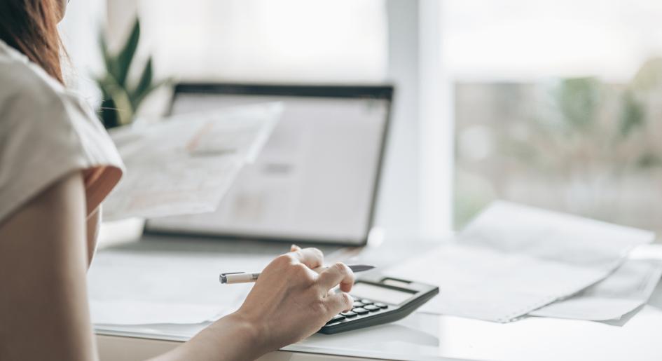 person using calculator at laptop