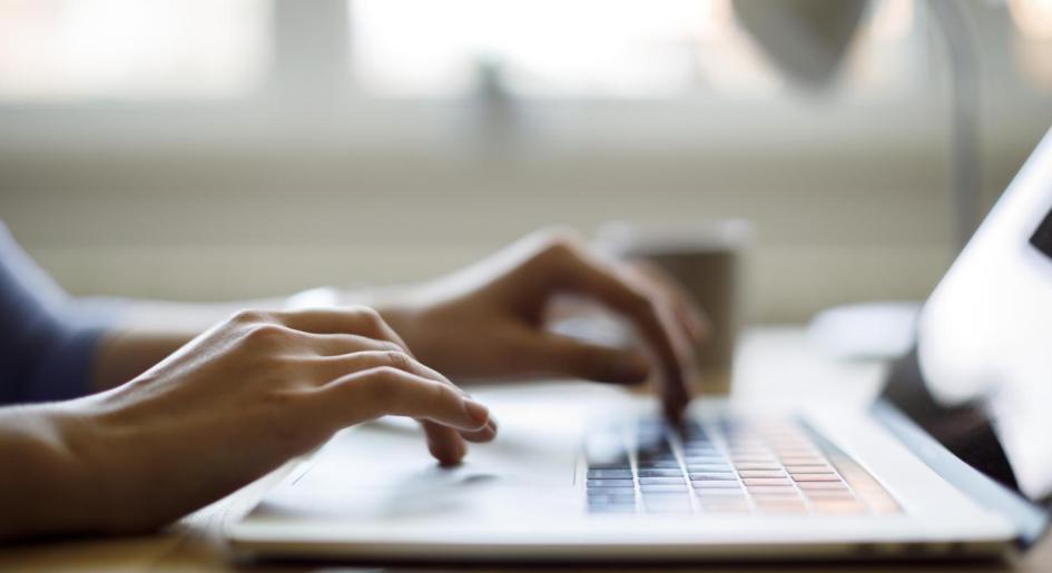 hands typing on laptop keyboard