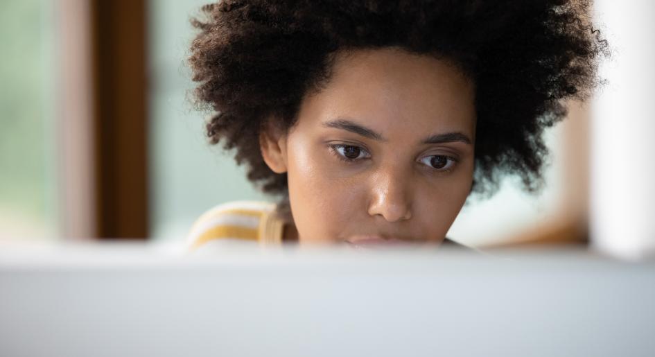 A woman sits at a laptop