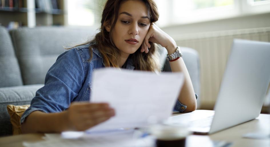 a woman looks at papers with a concerned look on her face