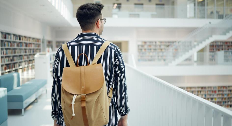 law student with backpack on in library