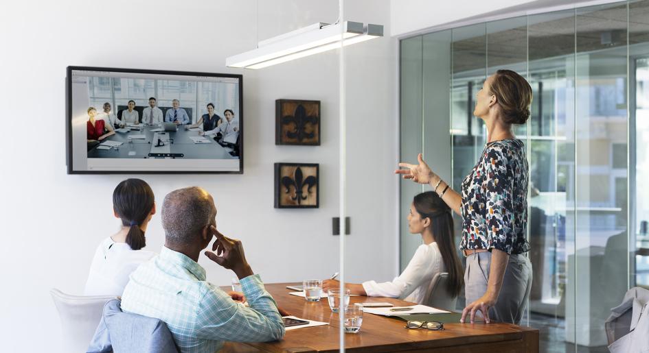 Professionals in conference room, participating in virtual conference call