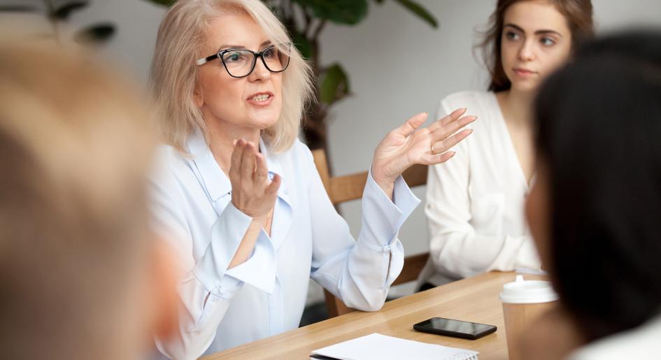 Person speaking to group at conference table