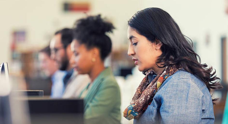 A group of people take a test at a test center