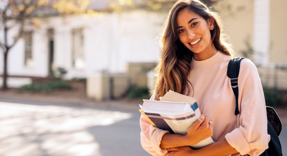 Law student holding textbooks on campus