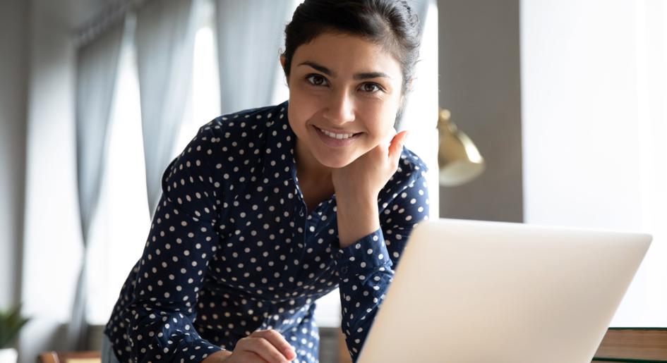 Person at laptop smiling at camera
